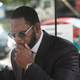 R. Kelly covers his mouth as he speaks to members of his entourage as he arrives at the Leighton Criminal Courts Building for a hearing on June 26, 2019 in Chicago, Illinois.